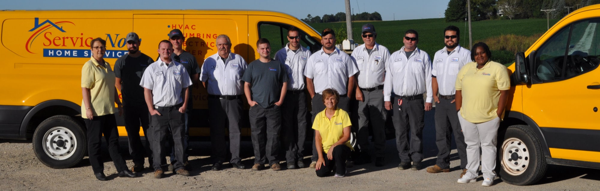 Service Now team photo in front of service vans.